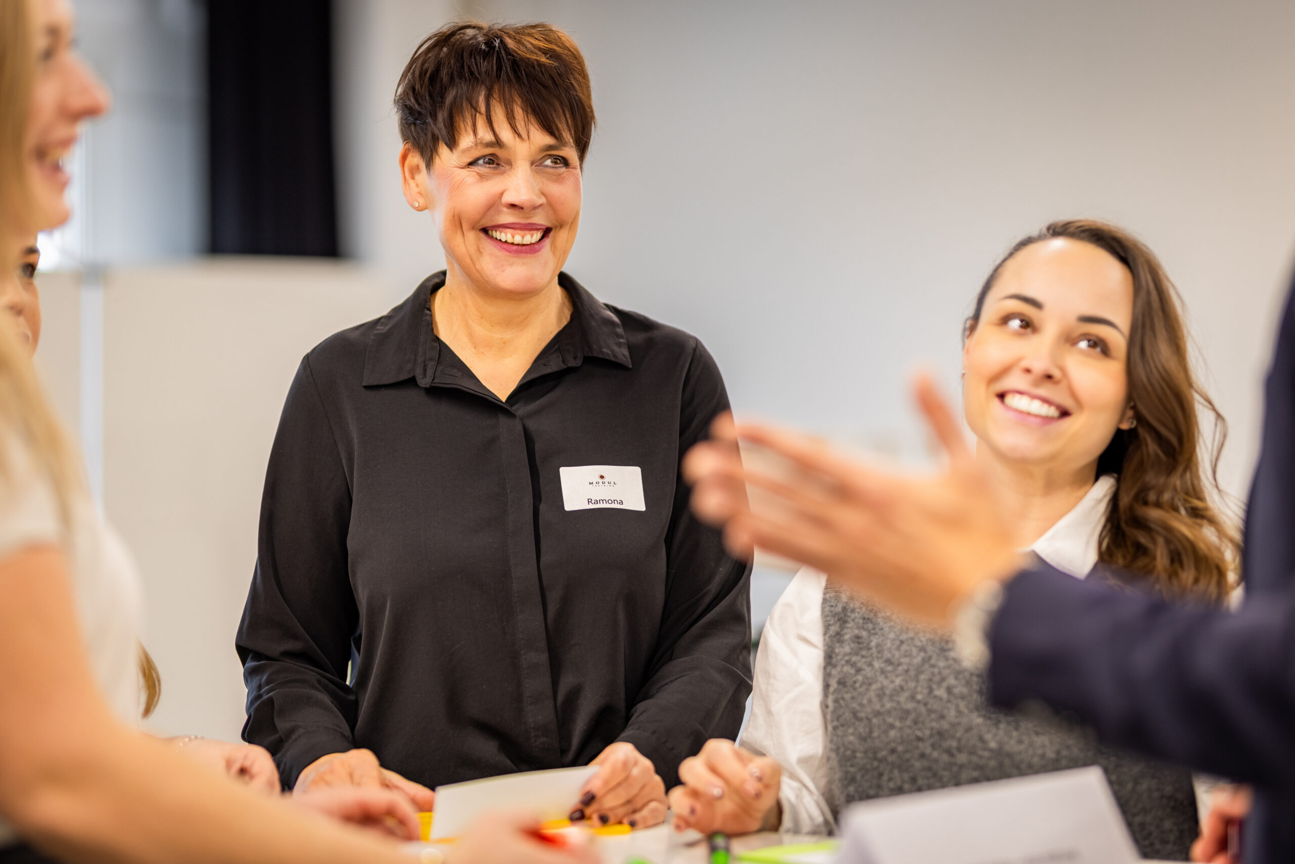 Teilnehmende lachen im offenen Austausch während eines HR-Seminars – MODUL TRAINING