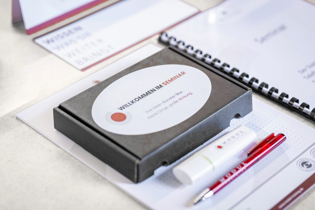 Seminarbox „Willkommen im Seminar“ mit Unterlagen, Notizbuch und Stift – MODUL TRAINING