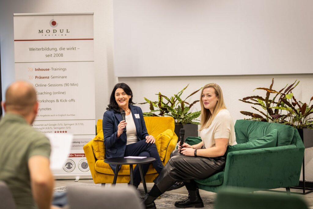 Moderiertes Gespräch auf einer Bühne mit Zuhörenden – MODUL TRAINING