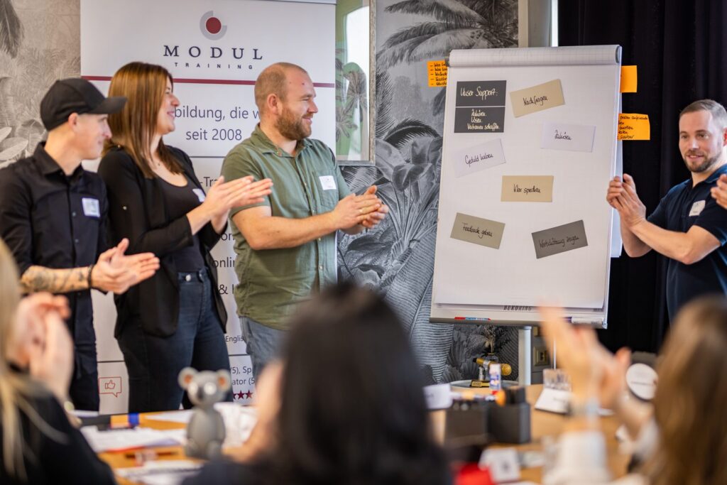 Seminargruppe stellt gemeinsam erarbeitete Ergebnisse am Flipchart vor – MODUL TRAINING