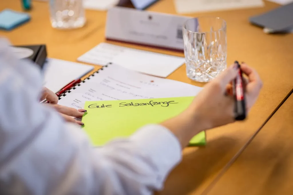 Teilnehmerin arbeitet im Workbook und notiert gute Satzanfänge
